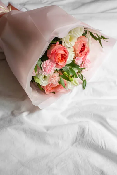 bouquet of flowers on bed. Roses, carnations, lisianthus.