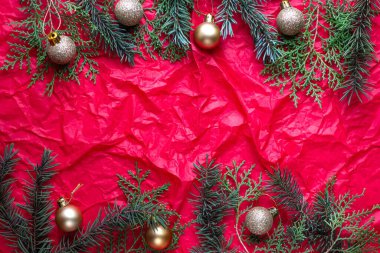 köknar dalları ve altın Noel topları ile kırmızı arkaplan