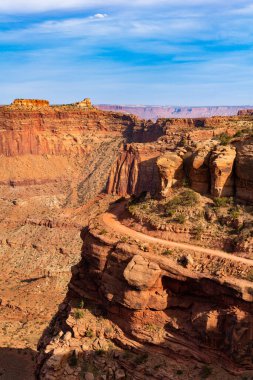 Shafer Kanyonu Yolu 4wd toprak yol Canyonlands Ulusal Parkı 'nın engebeli kanyonundaki uçurumlar boyunca kıvrılıyor.