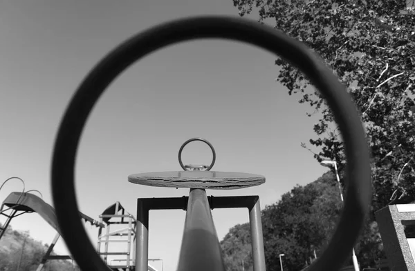 Boş bir çocuk parkının soyut siyah beyaz fotoğrafı. İki tahterevalli çemberi.