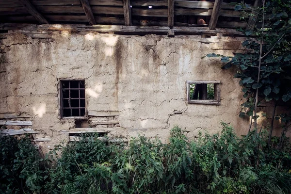 Sırp köyünde terk edilmiş bir evin iki pencereli eski kerpiç duvarı.