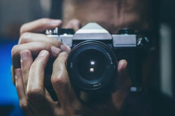 Eski bir film kamerasıyla fotoğraf çeken bir adam. Lense odaklan, kapat..