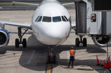 Havaalanı çalışanı bir uçağın güvertesine manevra yapıyor.