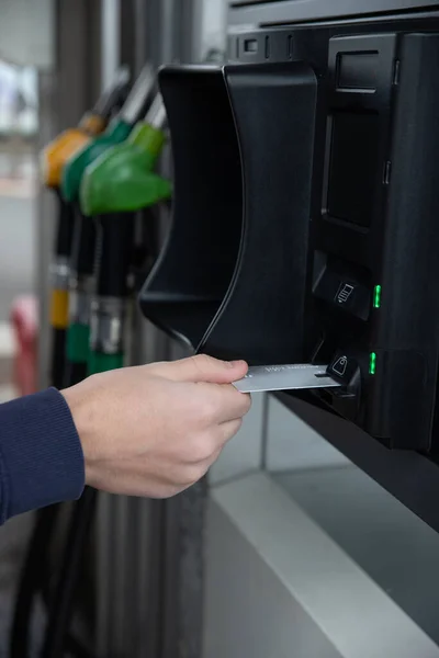 Arabasının deposuna benzin ya da mazot koyan ve kredi kartıyla ödeyen bir adamın el görüntüsü