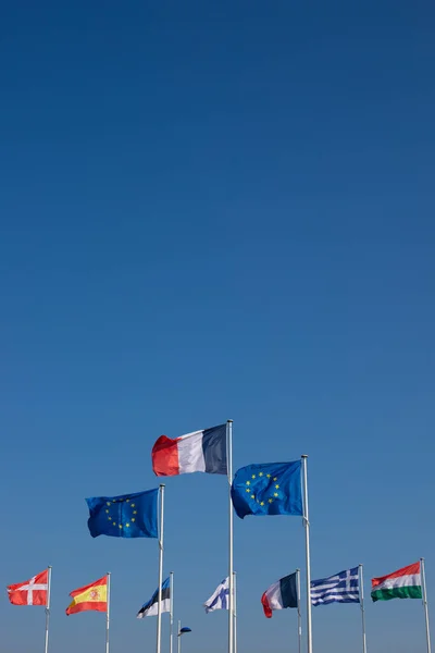 set of european union flags. In the center and in the foreground, the flag of Europe and the French flag. A beautiful blue sky in the background and a large space provided for the text