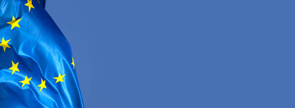 European flag in the wind with a beautiful blue sky in the background. Place to place text