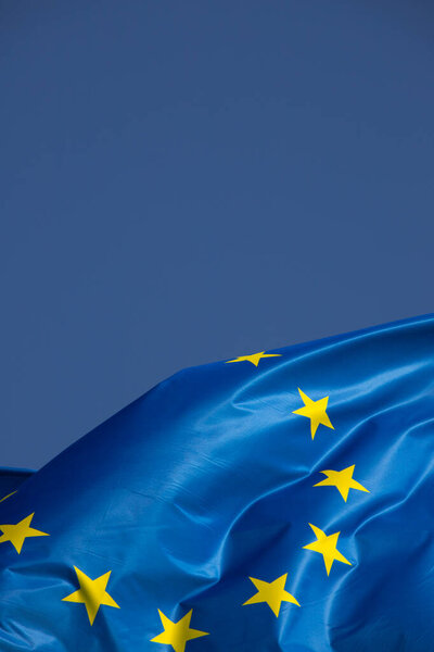 European flag in the wind with a beautiful blue sky in the background. Place to place text