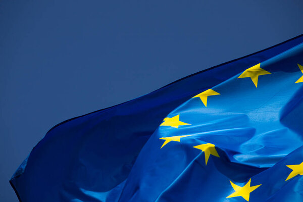 European flag in the wind with a beautiful blue sky in the background. Place to place text