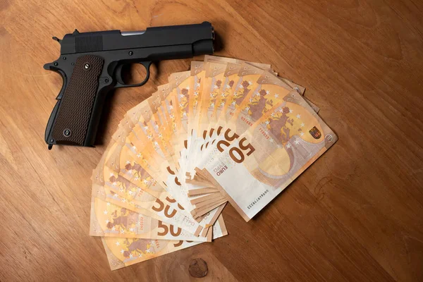 Silah masanın üzerinde 50 Euro 'luk banknotların yanında duruyordu.