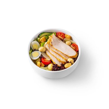 Salad with ham, eggs, cheese, tomatoes, lettuce, croutons, cucumbers and peppers in a bowl on a white background
