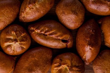 Tahta bir masada tavuklu bir sürü turta. Yatay yönelim 