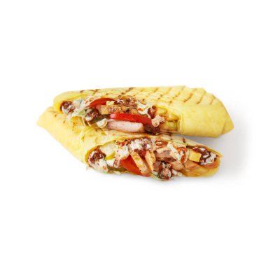 Shawarma cut in two in pita bread with chicken, tomatoes, cheese, cucumbers, cabbage and sauce on a white background