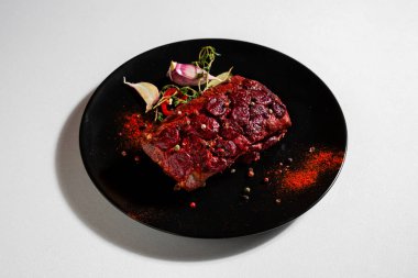Fried pork steak with cherries, peas, paprika, salt, thyme, chili and garlic in a plate on a white background