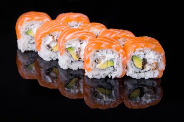 Roll with eel, salmon, avocado, rice, nori, and Philadelphia cheese on a black mirror background