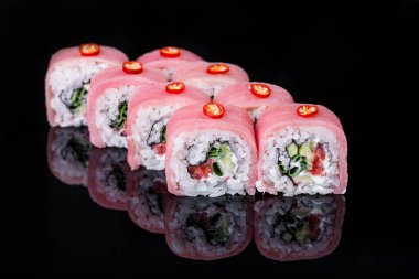 Roll with tuna, pepper, cucumber, onion, rice, Philadelphia cheese on a black mirror background
