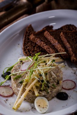 Bir tabakta yeşil bezelye, zeytin, taze filizler, turp ve ekmek filizleri