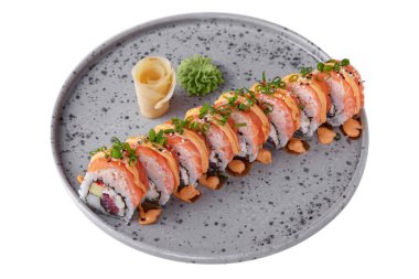 Rolls with salmon, tuna, avocado, rice, sauce, sesame seeds, onions, nori, Philadelphia cheese with wasabi, ginger on a platter on a white plate