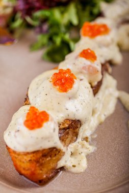 Kızarmış somon balığı, kırmızı havyar sosu, salata ve kekik. Dikey yönelim