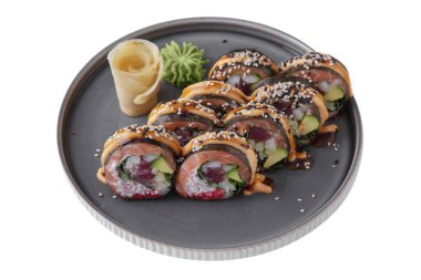 Rolls with salmon, tuna, avocado, rice, sauce, flying fish caviar, sesame seeds, cucumber, nori, Philadelphia cheese with wasabi, ginger on a platter on a white plate
