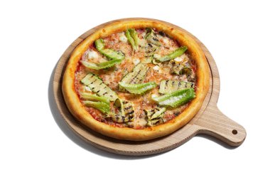 Pizza with cheese, salad, zucchini and sauce on a wooden board on a white plate