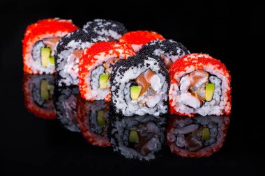 Roll with salmon, avocado, eel, rice, tobiko caviar and Philadelphia cheese on a black mirror background