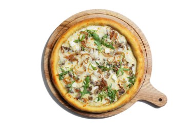 Pizza with cheese, arugula mushrooms, meat and sauce on a wooden board on a white plate