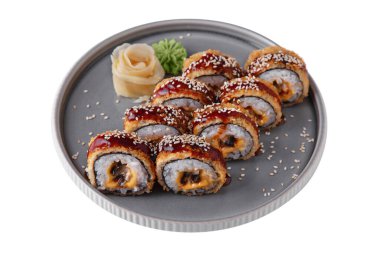 Warm roll with sauce, sesame, breading, nori, rice, cheese, seafood, wasabi, ginger on a gray plate on a white background