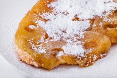 Beyaz bir tabakta pudra şekerli fırında elma halkaları. Yatay yönelim