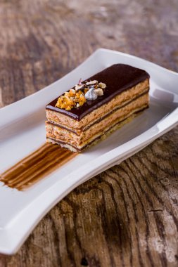Beyaz tabakta çikolata kremalı ballı pasta. Dikey yönelim