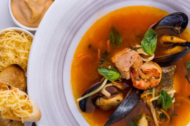 Balık çorbası, karides, midye, fesleğen, havuç ve ekmek.