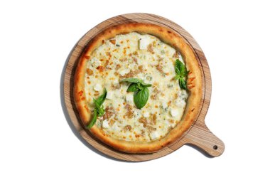 Pizza with different types of cheese, cheddar, mozzarella, dor blue, parmesan and basil on a wooden board on a white background