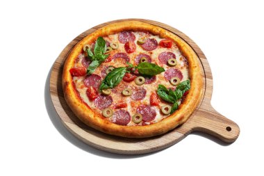 Pizza with cheese, olives, pepperoni, tomatoes, basil and sauce on a wooden board on a white background