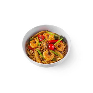 Spaghetti with corn, shrimps, mushrooms, onions, sesame seeds, pepper in a plate on a white background