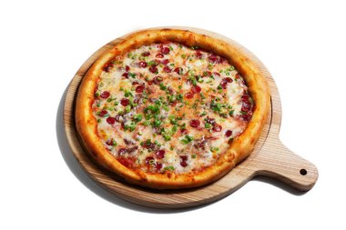 Pizza with cheese, sausages, green onions and sauce on a wooden board on a white plate