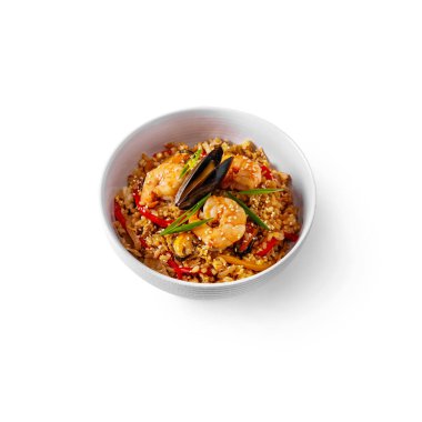 Rice with shrimps and mussels with onions, sesame seeds, pepper in a plate on a white background