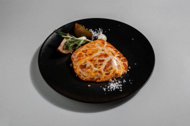 Raw marinated veined meat with peppercorns, paprika, tomatoes, salt, rosemary and garlic in a plate on a white background