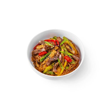Rice spaghetti with corn, pork, mushrooms, onions, sesame seeds, pepper in a plate on a white background