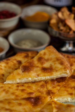 Tabağında peynir, üzüm, kurutulmuş elma, baharat ve bir bardak kırmızı şarap olan Khachapuri. Dikey yönelim 