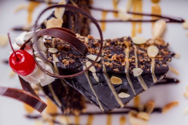 Fındıklı çikolatalı tatlı, çikolatalı cips, vişneli ve beyaz tabakta dondurma. Yatay yönelim