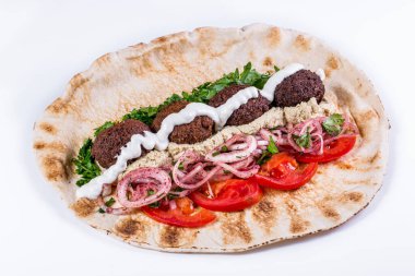 Falafel, domates, turşu, turşu, soğan turşusu, doğranmış maydanoz, sarımsak sosu ve soyutlanmış beyaz arka planda humus.