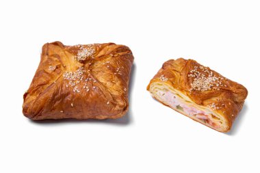 Samsa et ve susam tohumlarıyla beyaz bir tabakta, yakın plan. Tam ve bölgesel dolgu. Yatay yönelim 