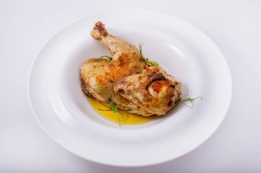 Beyaz yuvarlak tabakta yeşil bezelyeli tavuk leşinin yarısını kızarttım. Yatay yönelim