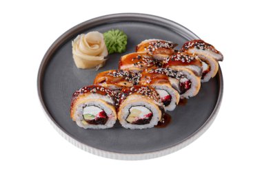 Rolls with eel, rice, sauce, sesame seeds, avocado, parmesan, nori, Philadelphia cheese with wasabi, ginger on a platter on a white plate