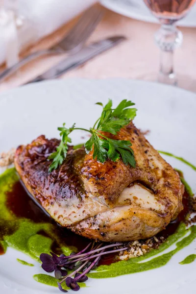 Kızarmış tavuk yarısı maydanoz, fasulye salatası ve beyaz yuvarlak tabakta pesto sosu. Dikey yönelim