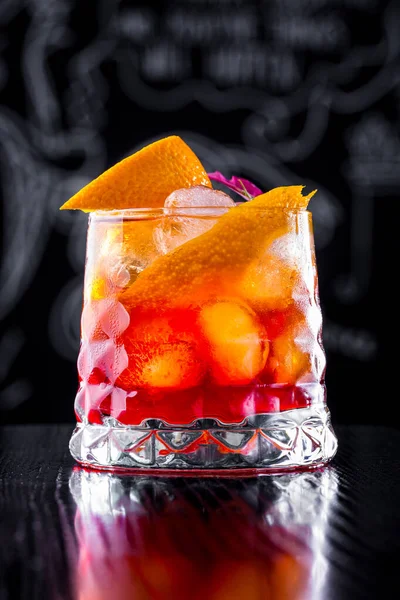 Cocktail Ice Orange Flower Petals Glass Stands Wooden Table Dark — Stockfoto