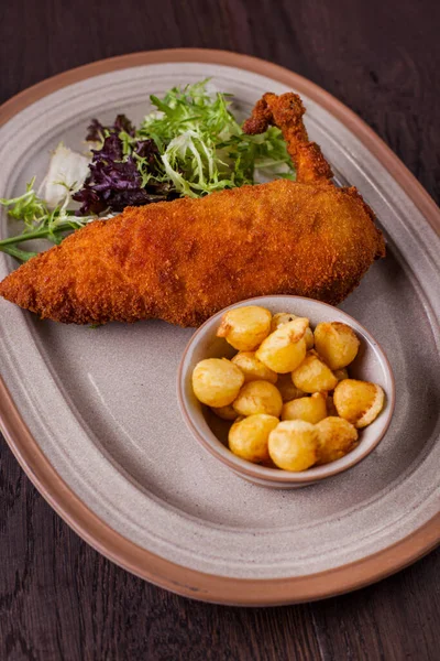 Biberiyeli tavuk pirzolası, peynir topları, oval tabakta yeşil ve mor salata. Dikey yönelim