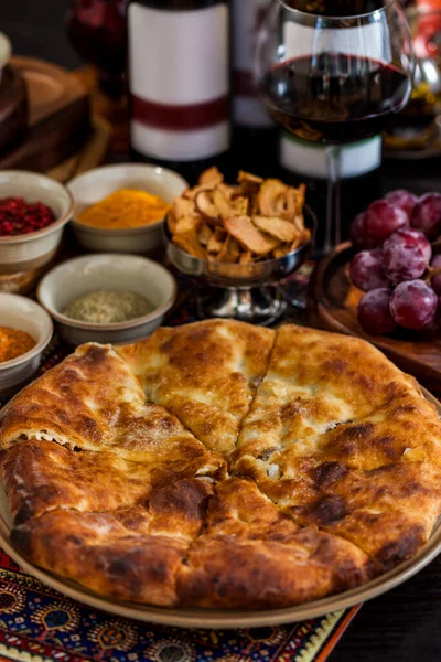 Tabakta turta, üzümler, kurutulmuş elmalar, baharatlar, bir bardak kırmızı şarap. Dikey yönelim 