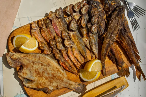 Assorted Grilled Fish Baked Wooden Board Lemons Table Napkins Forks — 图库照片
