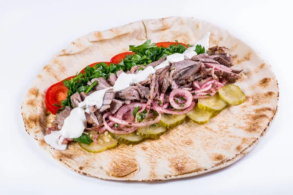 Opened shawarma with veal, tomatoes, pickles, pickled onions, chopped parsley and garlic sauce on isolated white background