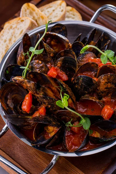 Domatesli midye, kabak ve peynirli patlıcan sotesi. Bir kazanda pişirilmiş. Midyeler saplı metal bir kalıba konur, yanında da buğday ekmeğinin tostları vardır..  